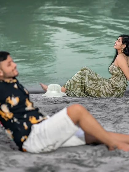 A relaxed, candid moment on the sandy shore. This shot feels natural and unposed, as if we've just captured a private moment during their riverside outing.