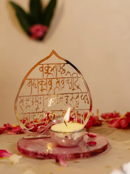 Illuminate your prayers with this beautiful tealight holder featuring the Ganesha mantra 'Vakratunda Mahakaya' in elegant cutwork. It casts a divine glow, creating a peaceful ambiance for worship.