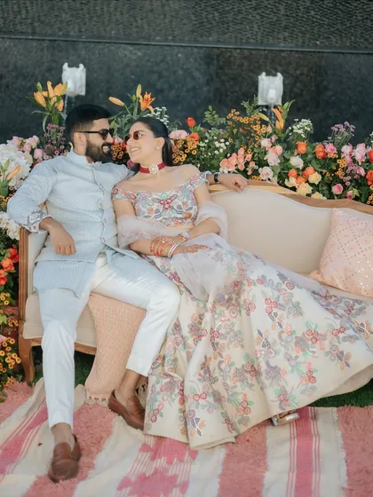 The couple sharing a happy moment during their welcome lunch. The vibrant floral decor creates a cheerful and romantic setting for their celebration.