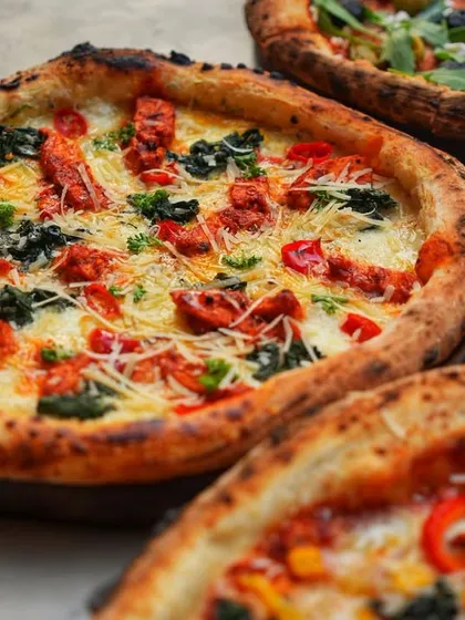 Sometimes, a picture of a perfectly cooked pizza is all you need. This one, with its vibrant toppings and charred crust, speaks for itself.