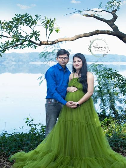 A serene maternity portrait by the water, with the mother-to-be in a flowing green gown. The natural landscape provides a stunning and peaceful backdrop.