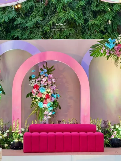 A close-up of the central arch and sofa on the pastel stage, a perfect spot for the bride.