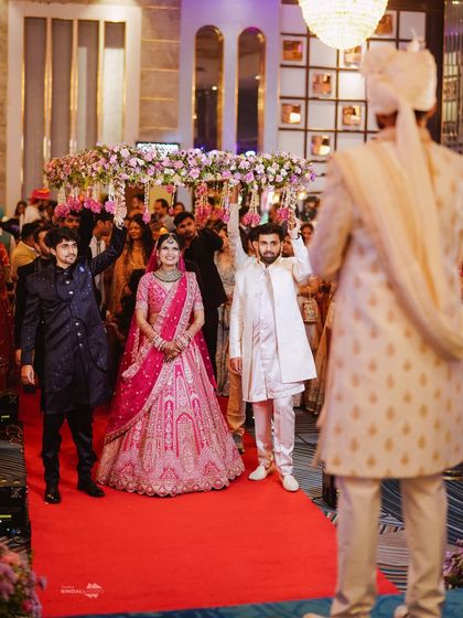 The bride's entry under the phoolon ki chaadar is a classic moment. This shot, taken from the groom's viewpoint, emphasizes the emotion and tradition of the bridal procession.