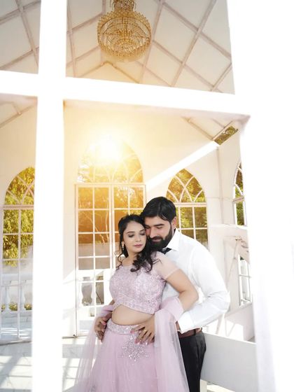 An intimate embrace in a sunlit, white-arched hallway. The soft light and romantic pose create a dreamy and beautiful portrait.