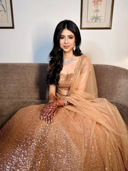 A modern reception look with golden hues and effortless elegance. The soft waves and shimmering makeup create a glorious and glamorous vibe.