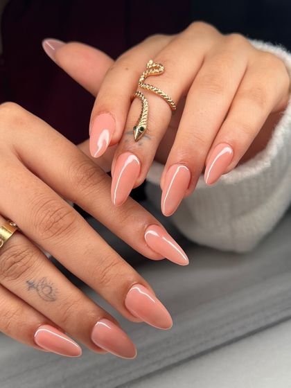 The perfect nude. These long, almond-shaped nails feature a soft, peachy-nude polish that is elegant, versatile, and always in style.