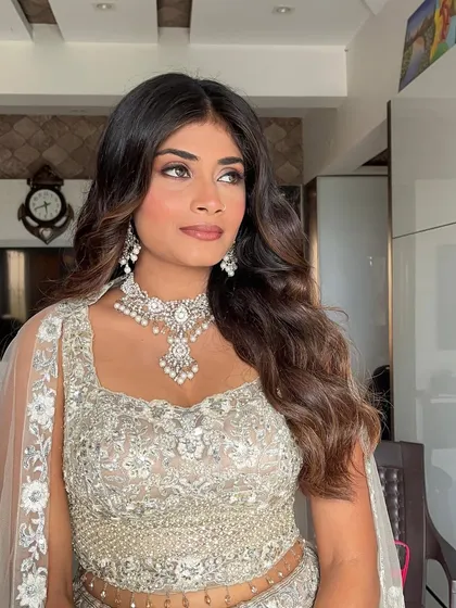 This side profile highlights the flawless base and softly defined eyes. Her makeup looks radiant and natural, never heavy or caked, allowing her own beauty to be the focus.