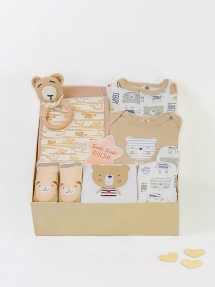 A 'Hello Little One' baby gift box, neatly packed with adorable bear-themed clothes and a rattle. This clean, top-down shot is perfect for an e-commerce product listing.