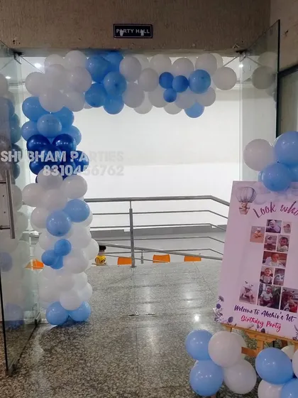 A simple blue and white balloon arch at the entrance to a party hall.