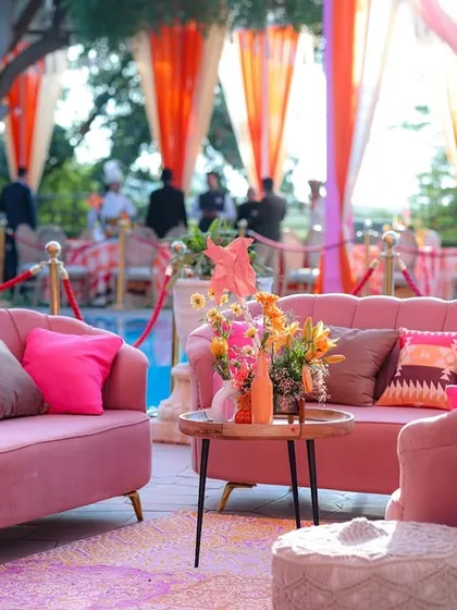 A full view of the lounge setup, with pink sofas arranged on a patterned rug, creating a perfect space for guests to relax and socialize.
