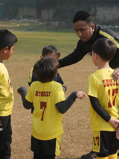 A coach talking to his team. We instill essential values in our young players from a tender age.