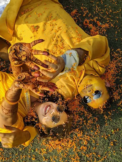 The haldi ceremony is all about unrestrained joy. This aerial shot captures the fun and playful energy of the moment, with the couple surrounded by marigold petals, lost in laughter. It’s a candid photograph that truly shows their personalities.