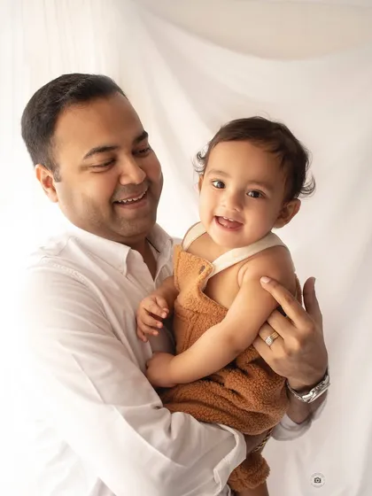 A happy dad holding his smiling baby. This candid shot is full of joy and shows the beautiful bond between a father and his child.