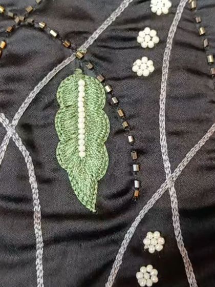 A detailed shot of the hand-embroidery on our modal satin co-ord set. The design features delicate leaves, pearl accents, and beadwork.
