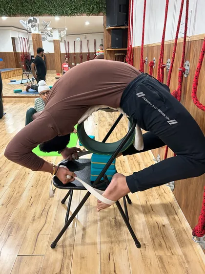 This student uses a chair, wheel, and strap to explore a full backbend. This advanced prop setup shows how we can creatively and safely work towards complex poses.