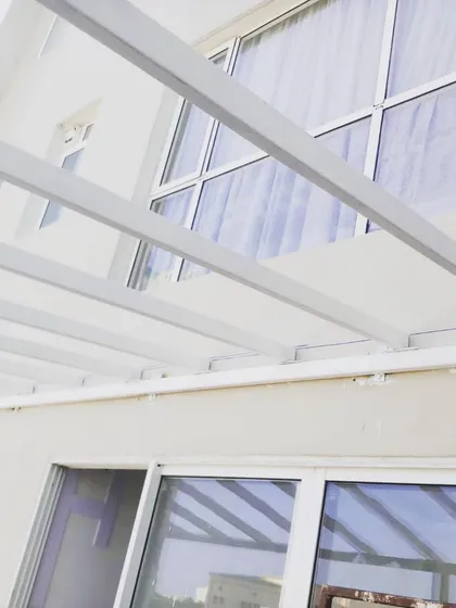 The simple, strong lines of the white pergola frame against the house. This style is incredibly versatile and works well with modern architecture.