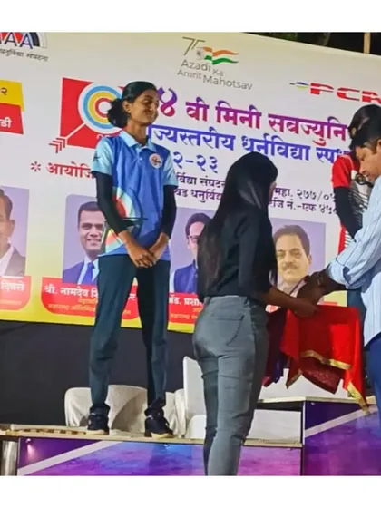 A student receiving her award on stage at the U14 State Level Archery Competition, where she won multiple silver medals.