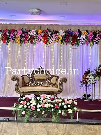 A wider view of the floral stage, showing the stage-front flower arrangements and the overall grand look.