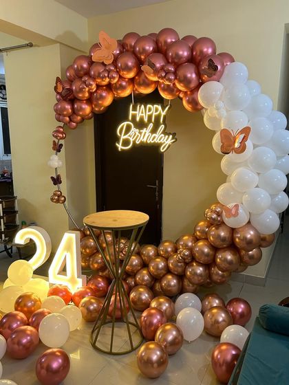 This is a duplicate of ID 10, 57, 76, 120, 210. An elegant and modern ring backdrop is perfect for home celebrations. The setup features a circular frame with a rose gold and white chrome balloon arrangement, a 'Happy Birthday' neon sign, and a light-up marquee number '24'.