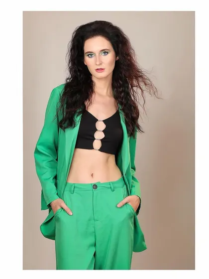 A full-body shot of the model in the green pantsuit, conveying confidence and style.
