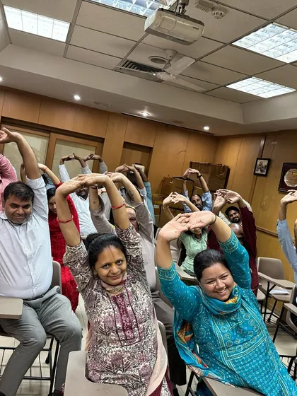 More smiles from a corporate session. Simple seated stretches can make a huge difference in relieving desk-related tension in the neck, shoulders, and back.