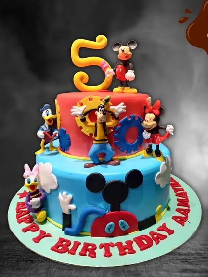 A fun and colorful two-tier cake celebrating the whole Mickey Mouse Clubhouse gang. It features Mickey, Minnie, Goofy, Donald, and Daisy, all ready to party for a fifth birthday.