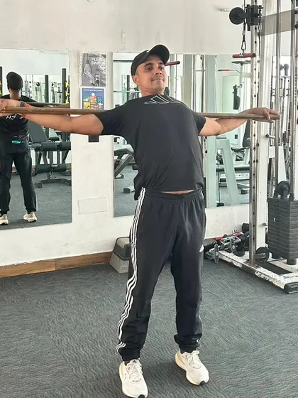 A backbend stretch with the stick to improve spinal flexibility.