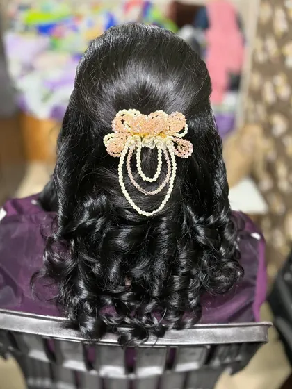 A simple yet elegant hairdo created based on the client's request. The soft curls are gathered at the back with a beautiful pearl and bead hair accessory.
