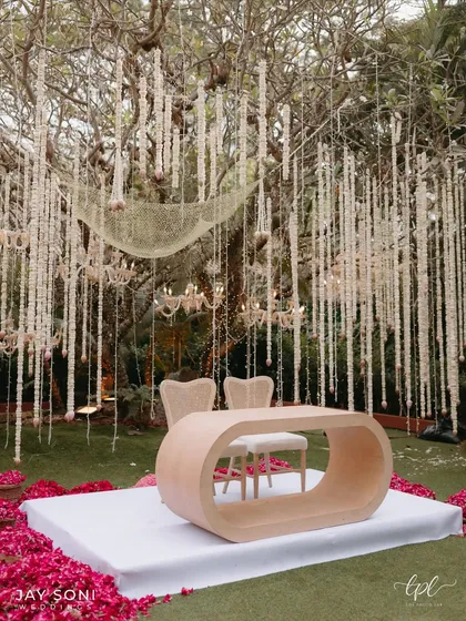 Another view of the modern, minimalist mandap, showing the beautiful contrast between the clean lines of the ceremony table and the organic feel of the hanging floral chandeliers.