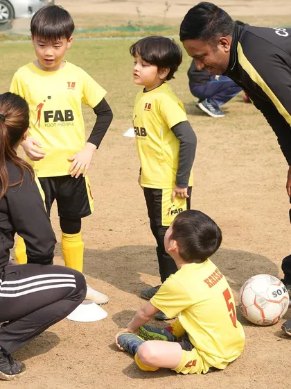 A typical huddle at our academy. Here, coaches and young players come together to discuss tactics and learn from each other, fostering a collaborative and supportive environment.