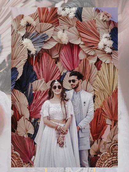 A stylish couple portrait in front of a vibrant, multi-colored backdrop during their Haldi event.