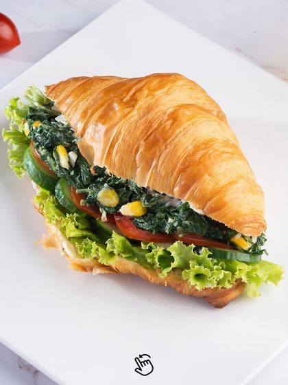 A healthy and delicious option, our spinach and corn croissant sandwich is packed with fresh vegetables.