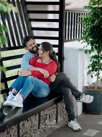 The couple sharing a laugh while seated together on a modern black bench.