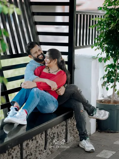 The couple sharing a laugh while seated together on a modern black bench.