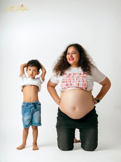 A cute pose from the mom-to-be and her son during their fun and messy paint-themed maternity shoot.