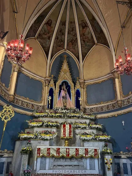 A wider view of the altar, showcasing the floral arrangements and the stunning domed ceiling of the basilica.