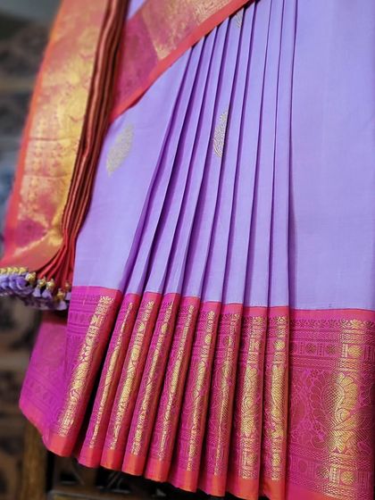 A close-up of fluffy center pleats on a beautiful lavender and pink cotton silk saree.