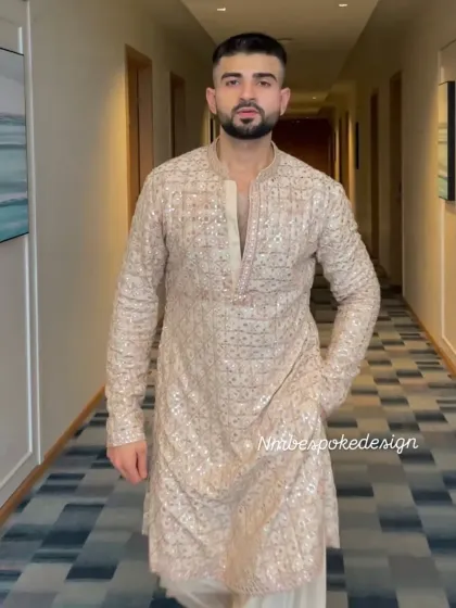 A full-length view of a client in a beige mirror-work kurta paired with a salwar. This is a classic look for any festive daytime event.