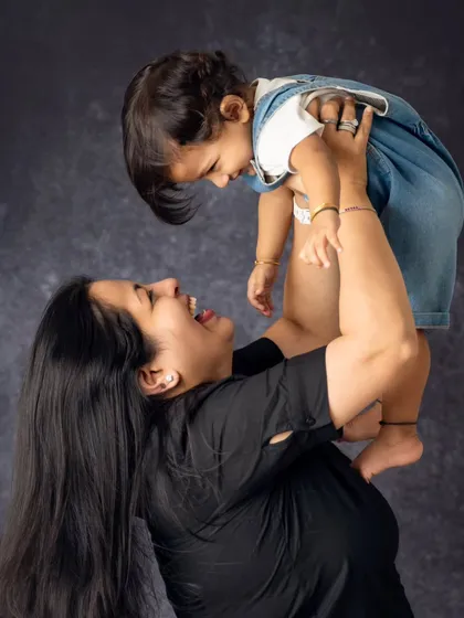 The pure joy of being lifted up by mom. We focus on capturing the dynamic, playful, and loving interactions that define your family's bond.