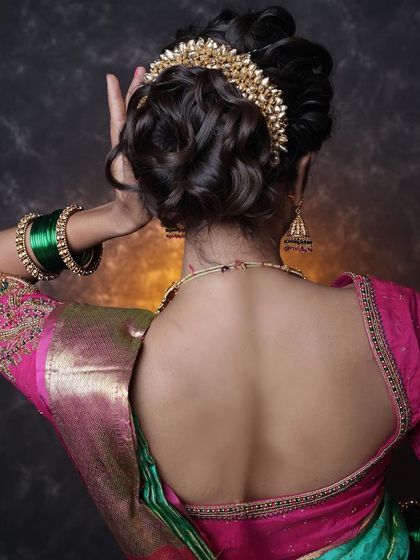 A beautiful messy bun updo, adorned with a delicate gold hair accessory. This is a great option for a reception or cocktail party.