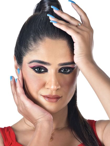 A beauty close-up highlighting a creative graphic eyeliner look. The sharp black liner is accented with a red wing, demonstrating precision and artistry for editorial concepts.