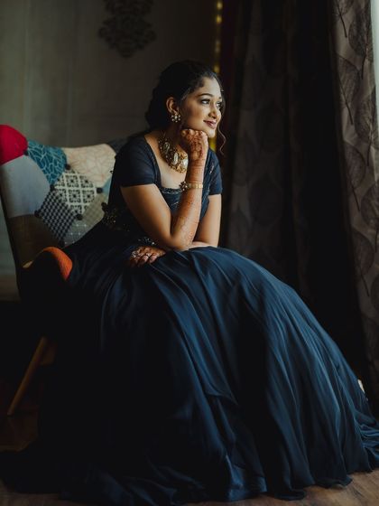 A pensive, artistic shot by the window. The lighting highlights the contours of her face and the soft waves in her hair.