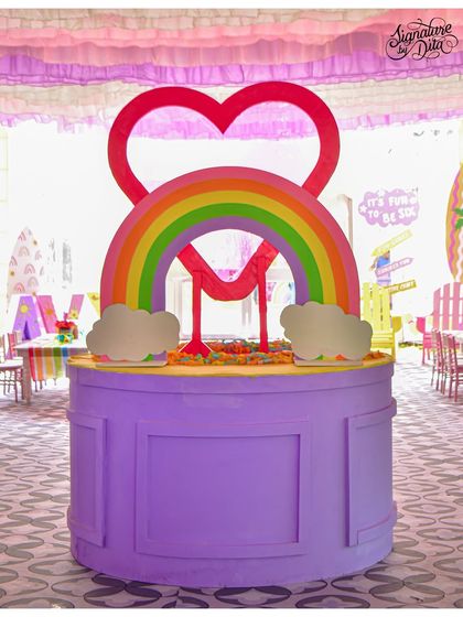 A custom-made prop featuring the birthday girl's initial 'M' under a rainbow. This piece was a central part of the decor, adding a personal touch to the celebration.