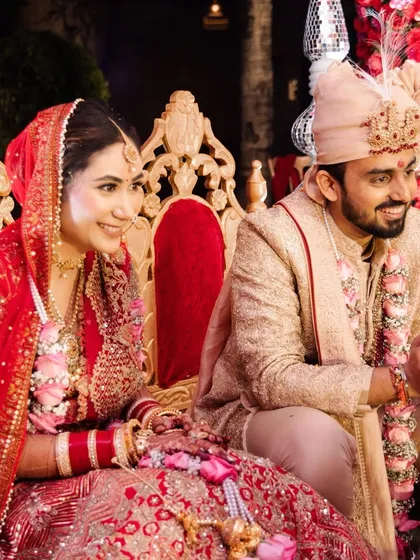 A candid moment of joy for the couple, seated in their grand red and gold themed mandap. I focus on creating a comfortable yet regal space for you to enjoy your ceremony.