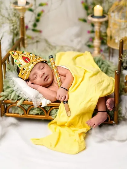 A sleeping newborn as Ladoo Gopal, resting peacefully on a miniature bed. This serene portrait is a beautiful way to commemorate your baby's first Janmashtami.