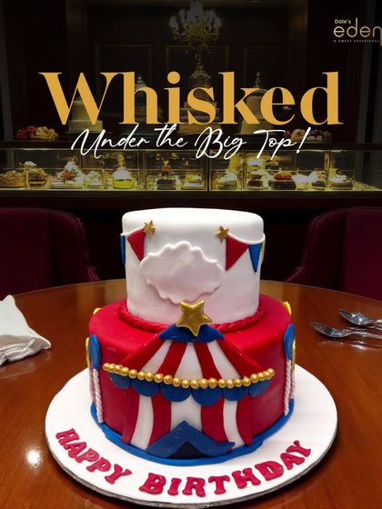 Whisked under the big top! This vibrant, two-tier circus-themed cake is decorated with red and white stripes, stars, and bunting, bringing all the fun of the circus to a birthday celebration.