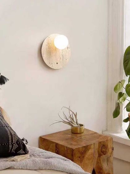 A beautiful wall sconce made from natural stone. The light glows through the material, highlighting its unique patterns and creating a warm, organic feel.