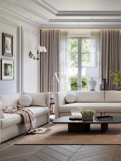The placement of art and accessories is key to personalizing a space. Here, a gallery wall and carefully chosen table lamps add character to the room's neutral, classical backdrop.