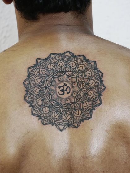 A beautiful Om mandala tattoo on the back. This is the kind of intricate and spiritual work our artist Roshni specializes in.