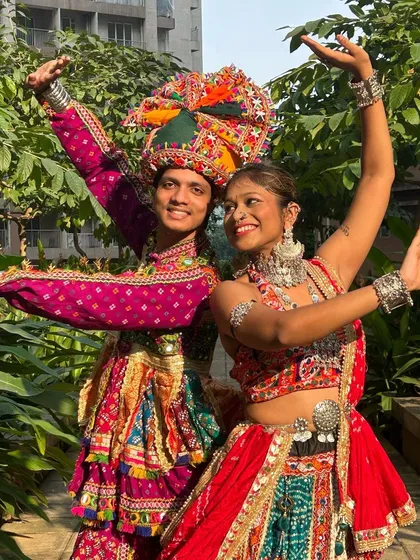 Arms up and ready to dance! This couple radiates joy and festive spirit in their matching traditional attire.